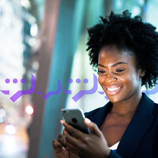 VoIP Texting Blog Thumbnail Photo of a smiling woman typing a text into her cell phone.