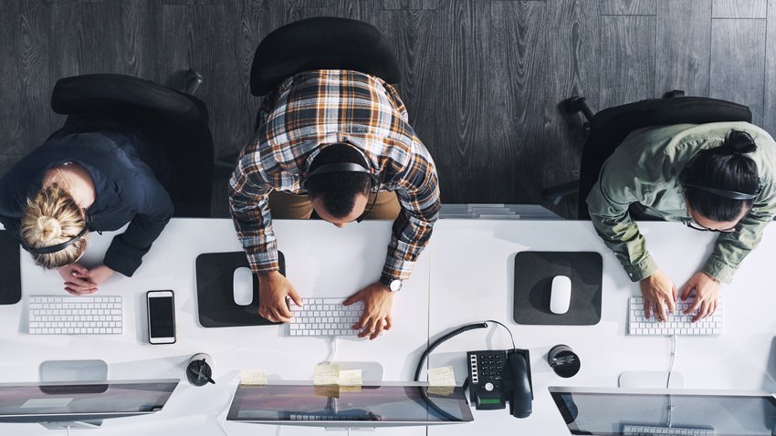 Agentes de contact center Foto en gran angular de un grupo de agentes de call center trabajando en una oficina